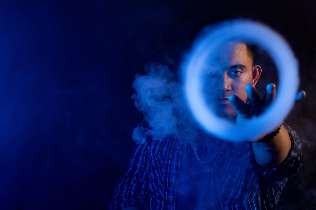 man blowing smoke rings with vape