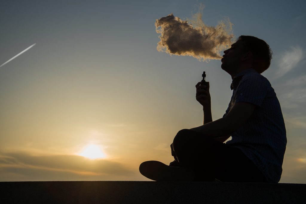 person vaping at sunset